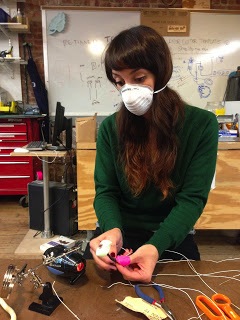claire soldering wires and wearing a mask